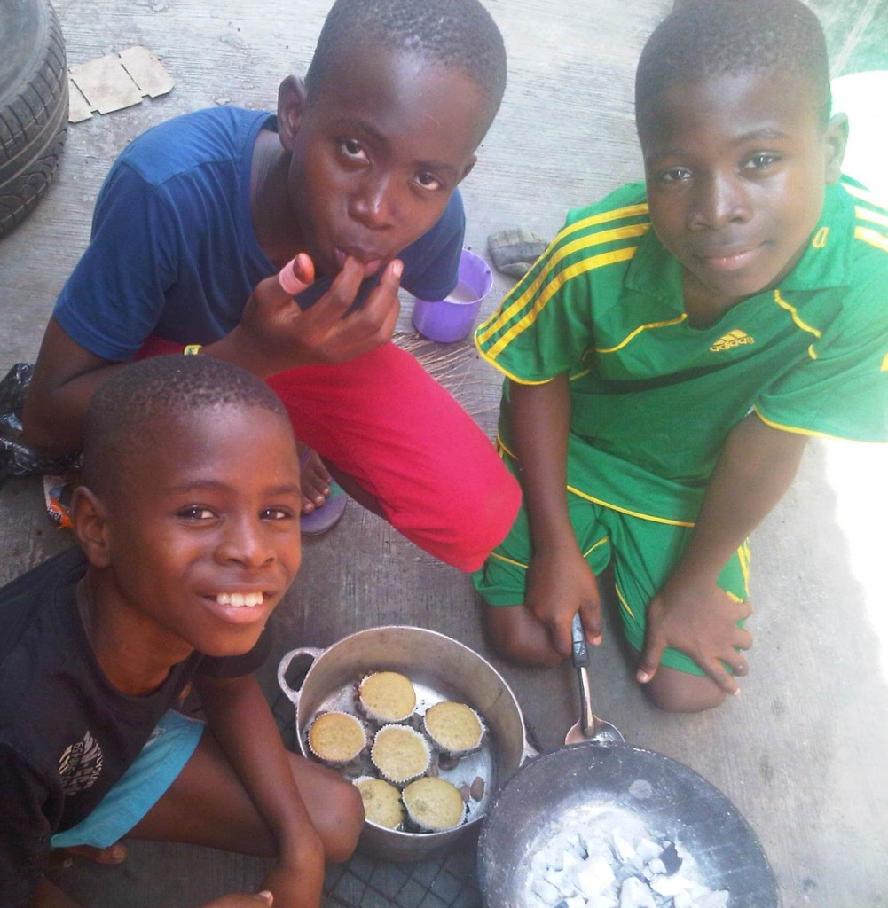 Photo: Wed. Dec. 11, 2013 - My 10, 14, and 12 year old sons, and the 50% pineapple peel cakes they baked WITHOUT an oven. All they used was the charcoal stove, and a heavy metal pot I brought ALL the way from Cotonou (The 14 year old has a finger in his mouth. That's where most of the first set  of cakes they made went...before they recently began selling them...lol!)